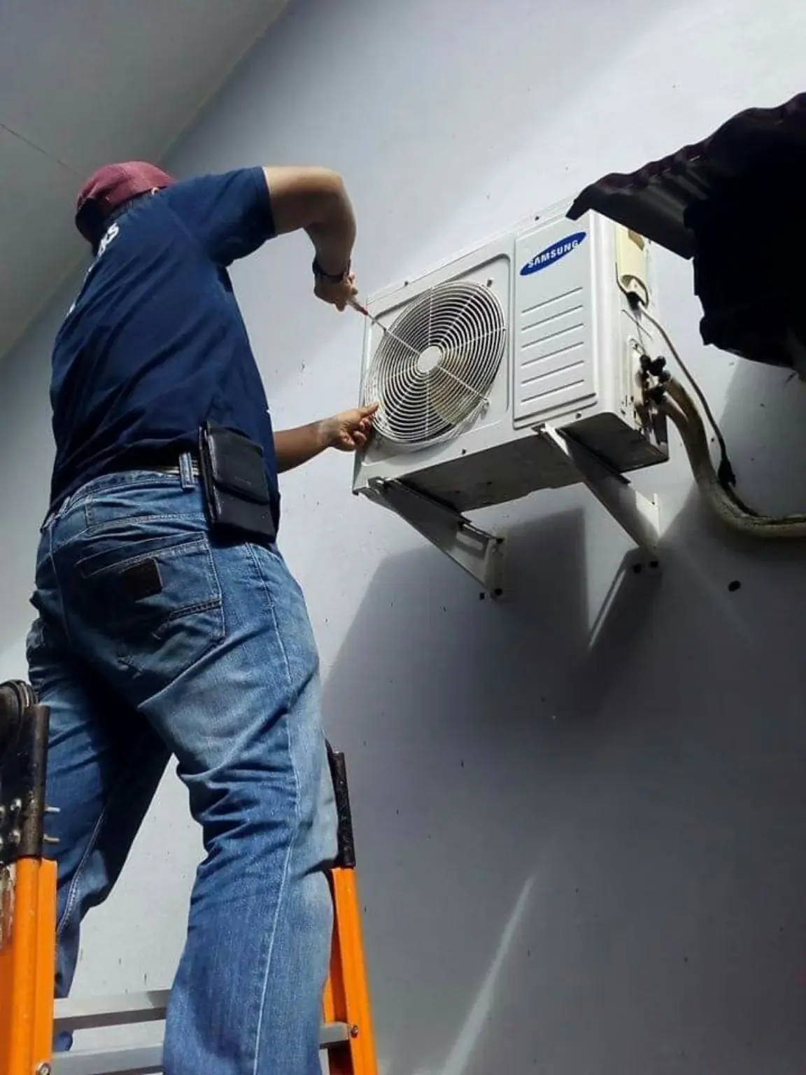 Technician working on an outdoor air-conditioning unit